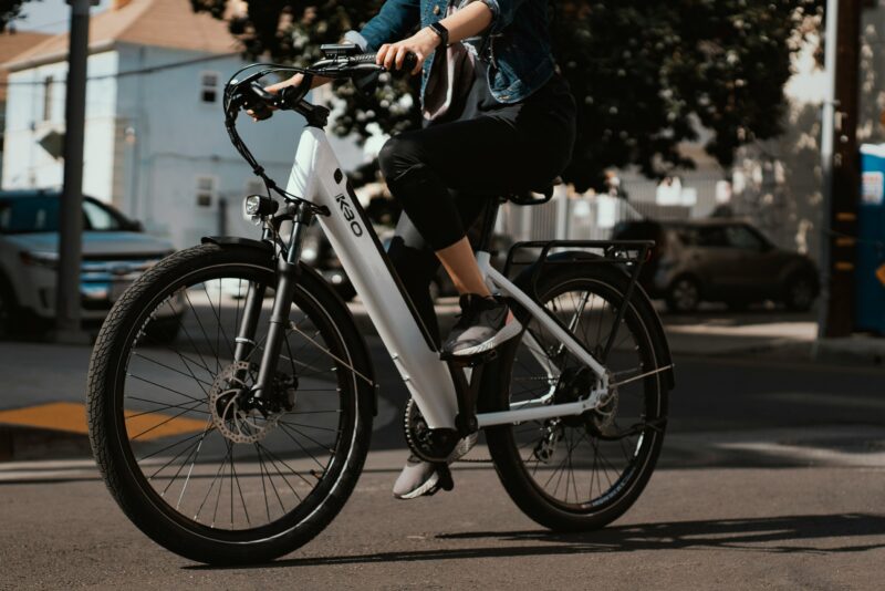 市街地を走る白い通学向け電動アシスト自転車