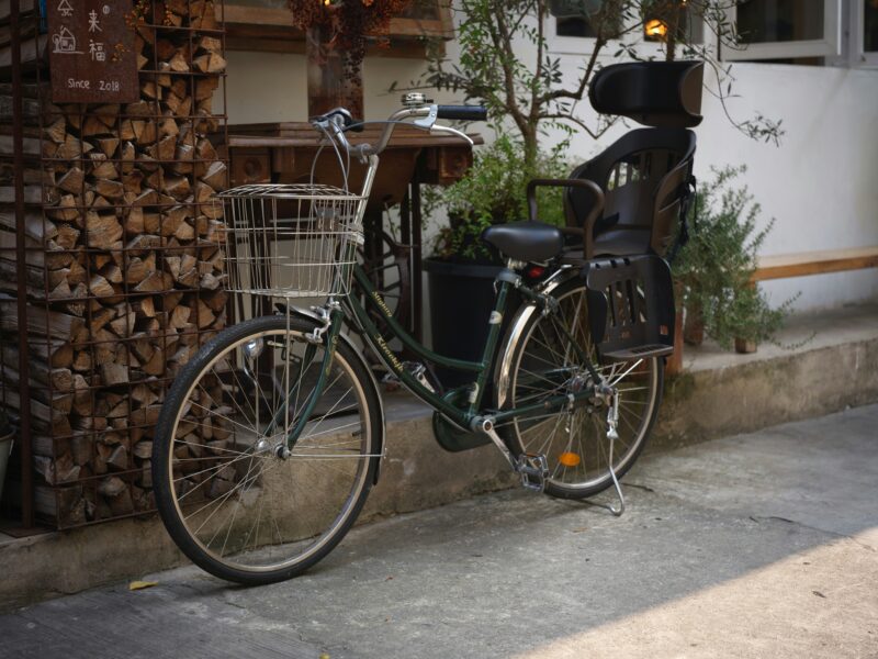 前カゴと大型の後ろ子ども乗せシートを備えた緑色の自転車