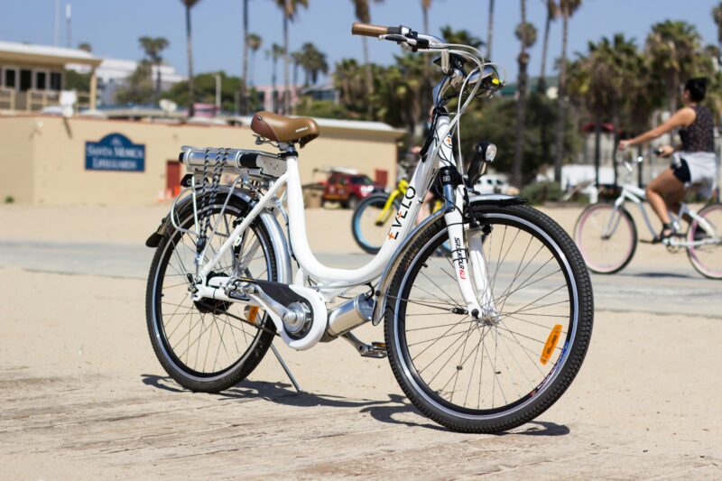 海外のビーチエリアに置かれた白いEVELO電動アシスト自転車