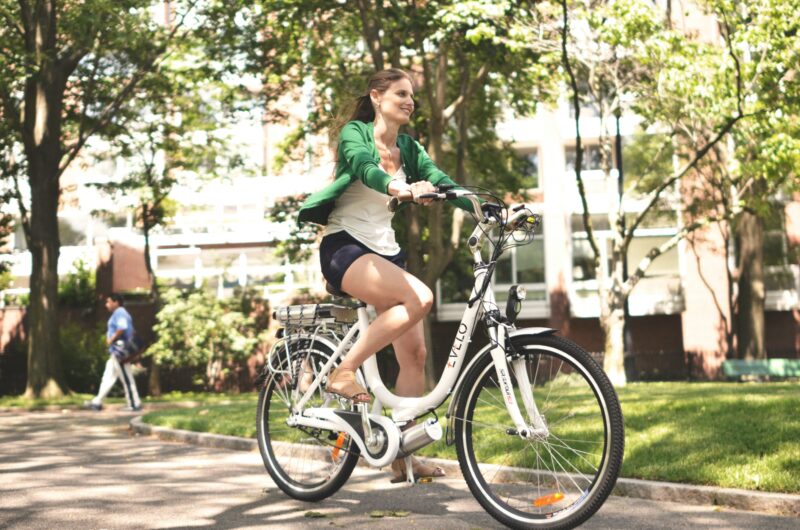 白いステップスルー型の海外電動アシスト自転車に乗る女性